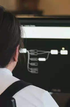 Un étudiant devant une architecture affichée sur un écran